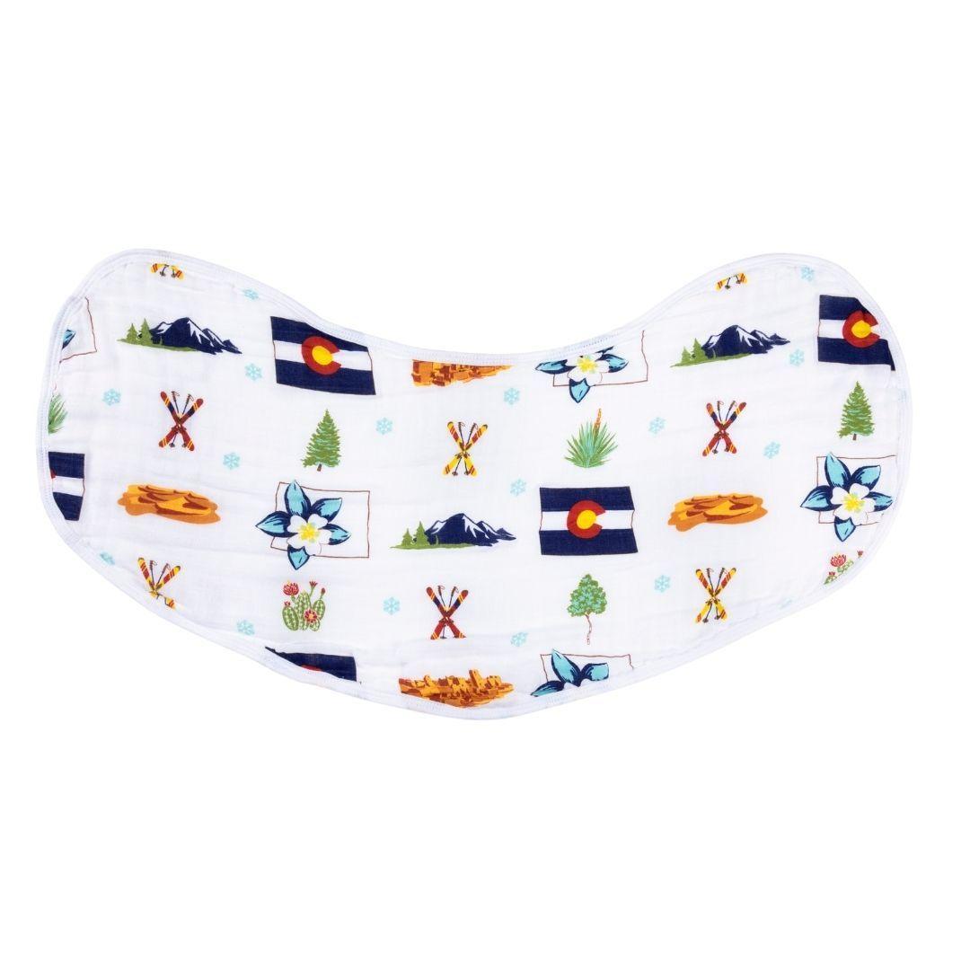 The curved Colorado burp cloth and bib combo on white, printed with mountains, skis and the state flag.