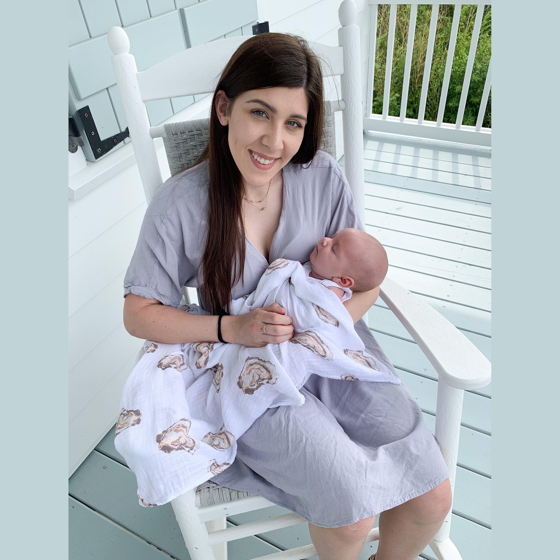 White muslin swaddle blanket with cute oyster illustrations and the text "Aw Shucks!" in playful blue font.