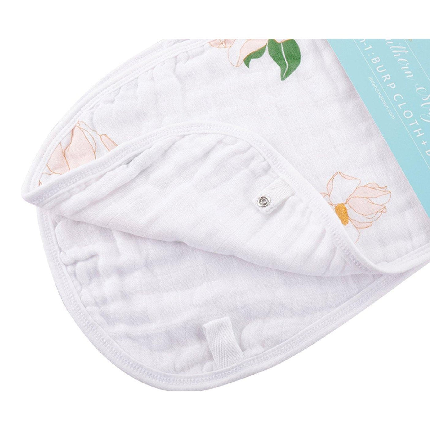 Baby bib and burp cloth set with Southern Magnolia print, featuring delicate white flowers on a soft pink background.