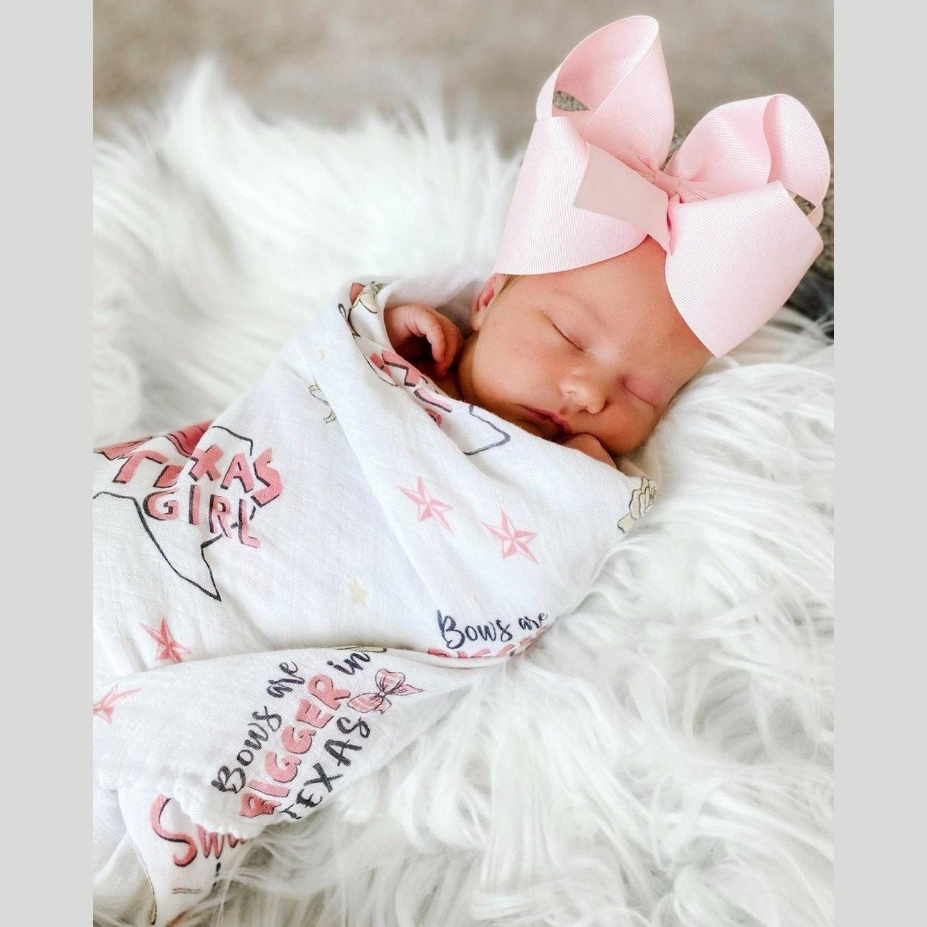 Texas-themed baby girl gift set with a muslin swaddle blanket and burp cloth, featuring pink and white designs.