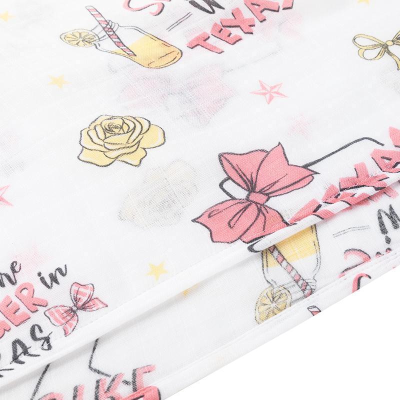 Texas-themed baby girl gift set with muslin swaddle blanket and burp cloth, featuring pink and white designs.