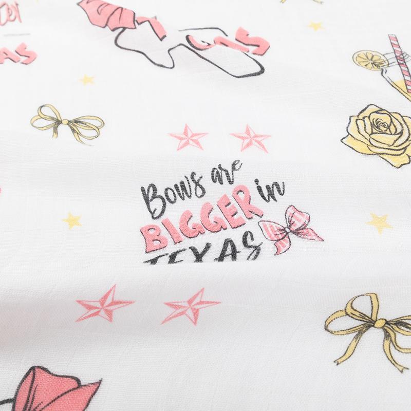 Texas-themed baby girl gift set with a muslin swaddle blanket and burp cloth, featuring pink and white designs.