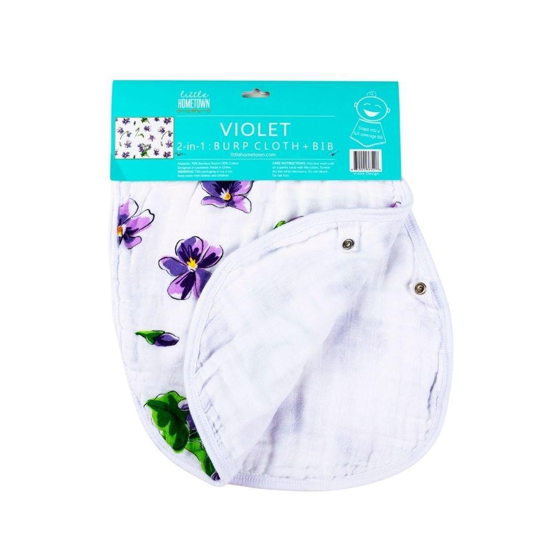 Gift set with a violet baby muslin swaddle blanket and matching burp cloth/bib combo, neatly folded.
