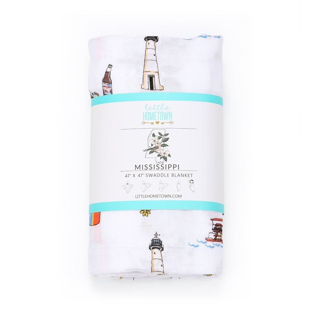 The Mississippi muslin swaddle blanket, rolled and tied in its printed Little Hometown band.