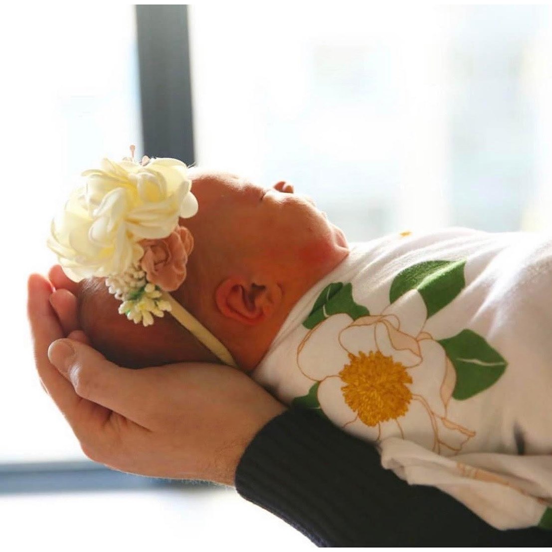 Soft muslin swaddle blanket with delicate Southern Magnolia floral print, perfect for newborns and baby gifts.