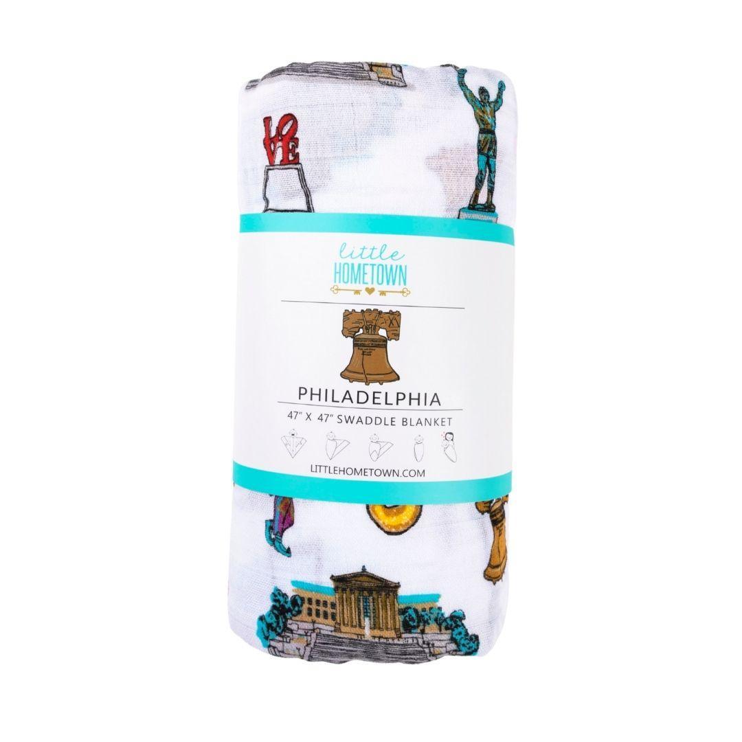 Philadelphia baby muslin swaddle blanket printed with the Liberty Bell, cheesesteak, soft pretzel and water ice