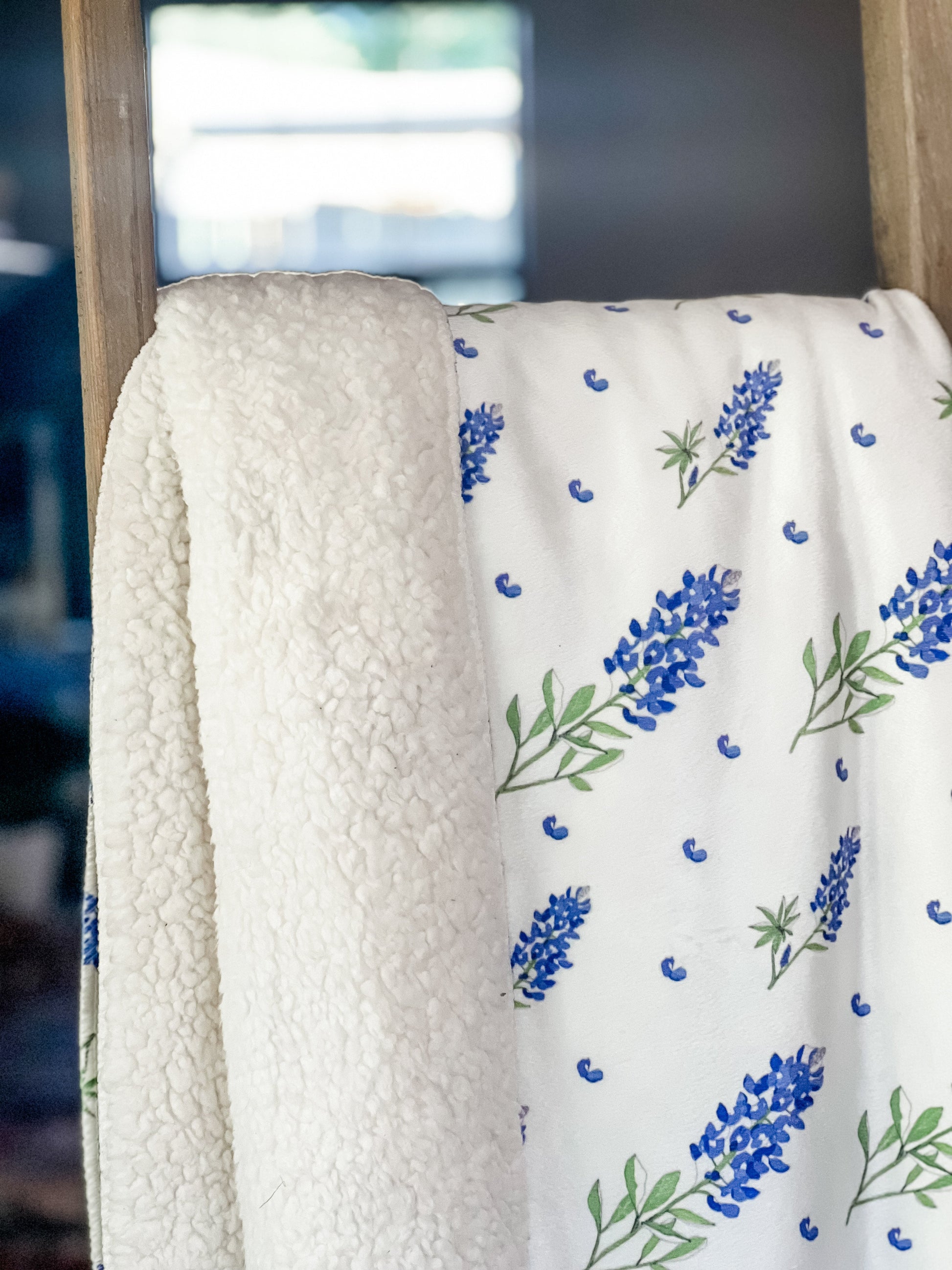 Bluebonnet-patterned plush throw blanket in shades of blue and green, measuring 60x80 inches, on a white background.