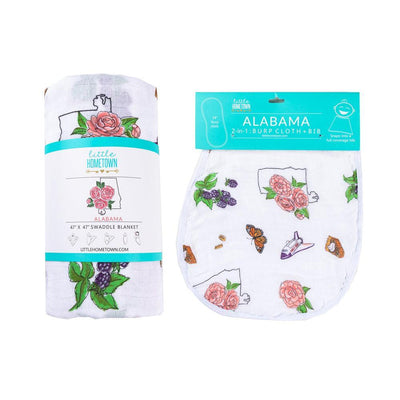 The Alabama Floral swaddle rolled beside its matching burp cloth and bib combo, blooms showing.