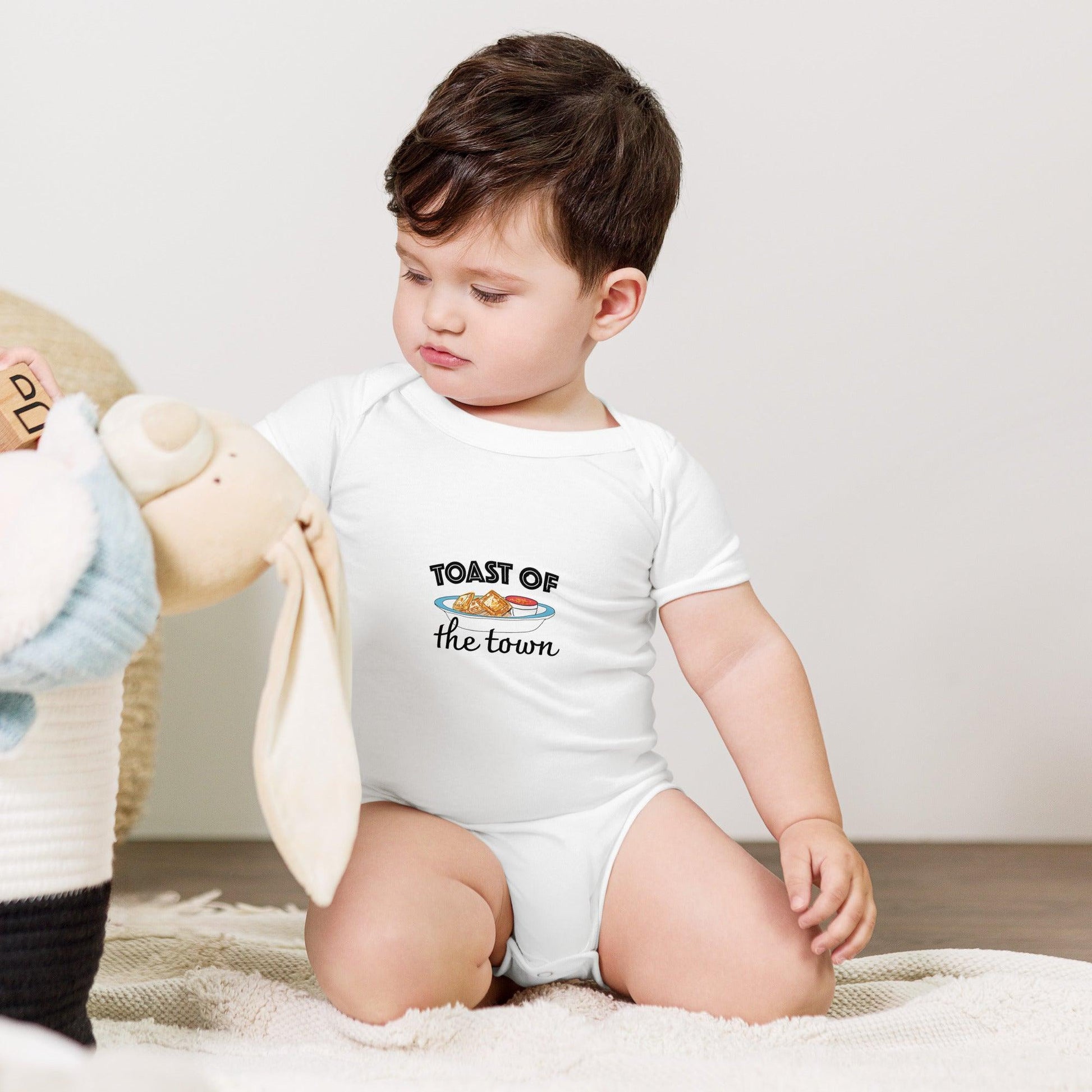 Baby wearing a onesie with a Missouri themed "Toast of the Town" text and a cute ravioli graphic, set against a white background.