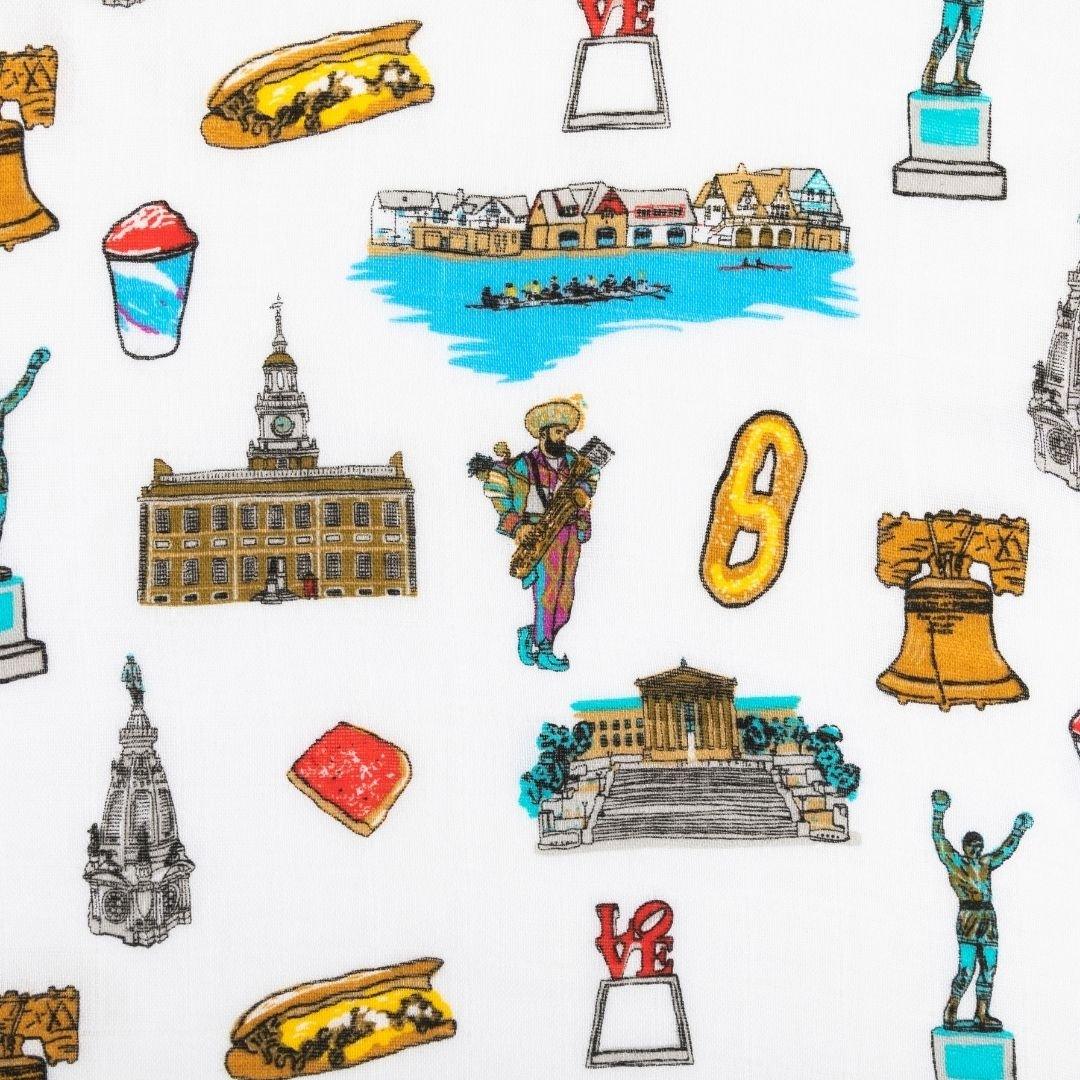 Close up of design elements on Philadelphia-themed blanket featuring iconic state symbols and landmarks in vibrant colors including Love statue, Rocky, Tomato Pie, water ice, cheesesteak and a mummer