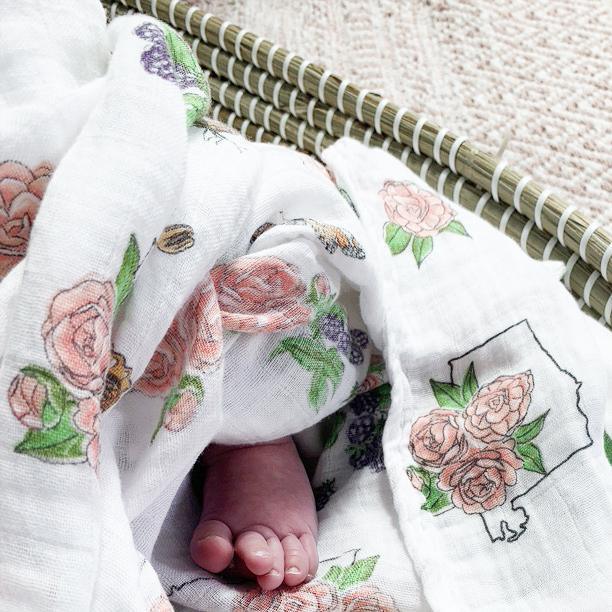 White muslin swaddle blanket with delicate pink and green floral pattern, featuring "Alabama Baby" text in cursive.