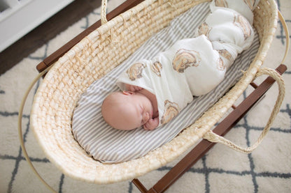 White muslin swaddle blanket with playful oyster illustrations and the text "Aw Shucks!" in blue script.