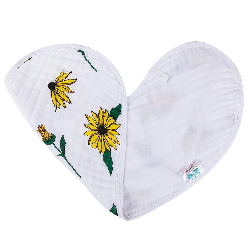 Baby bib and burp cloth set with black-eyed Susan floral pattern on white fabric, displayed on a wooden surface.