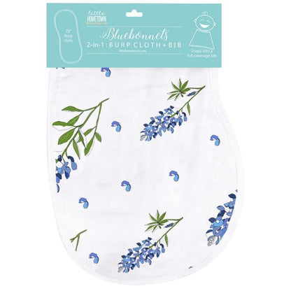 Baby bib and burp cloth set with bluebonnet floral pattern on white fabric, displayed on a wooden surface.
