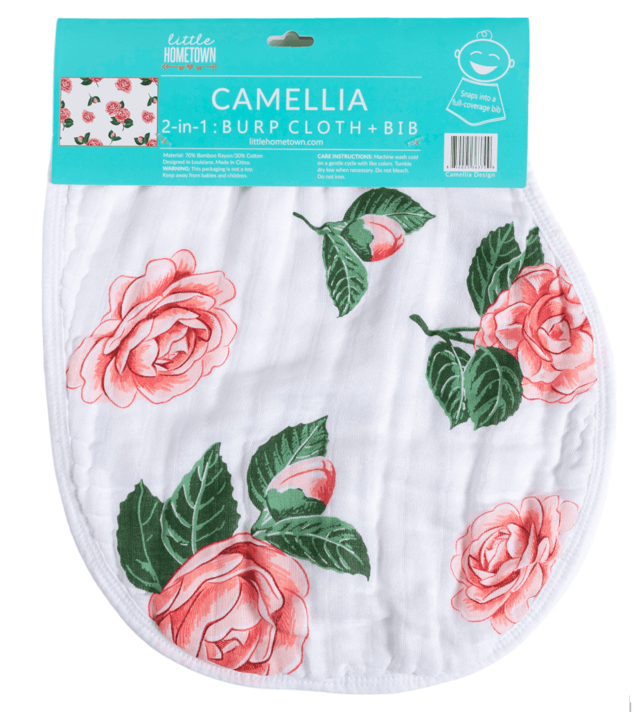 Pink and white floral baby bib and burp cloth set with camellia pattern, neatly folded on a white background.