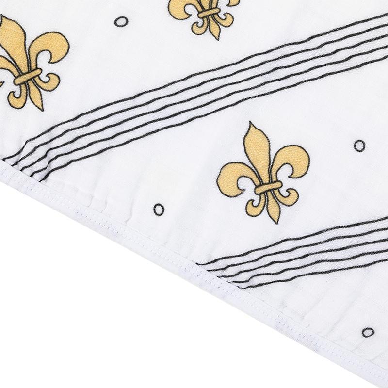 Baby bib and burp cloth set with blue fleur-de-lis pattern on white fabric, displayed on a wooden surface.