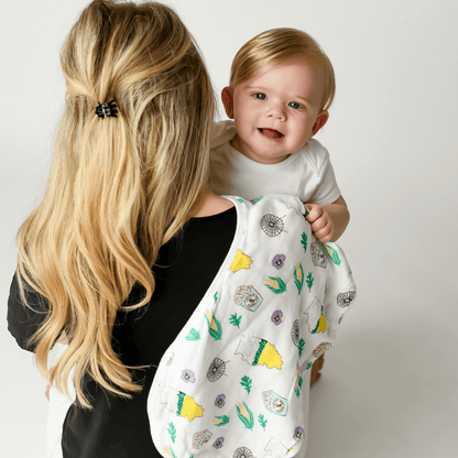 White baby bib and burp cloth set featuring "Illinois" text and state outline with playful icons in blue and red.