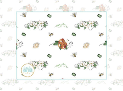 Baby bib and burp cloth set with North Carolina floral design, featuring vibrant flowers and state outline.