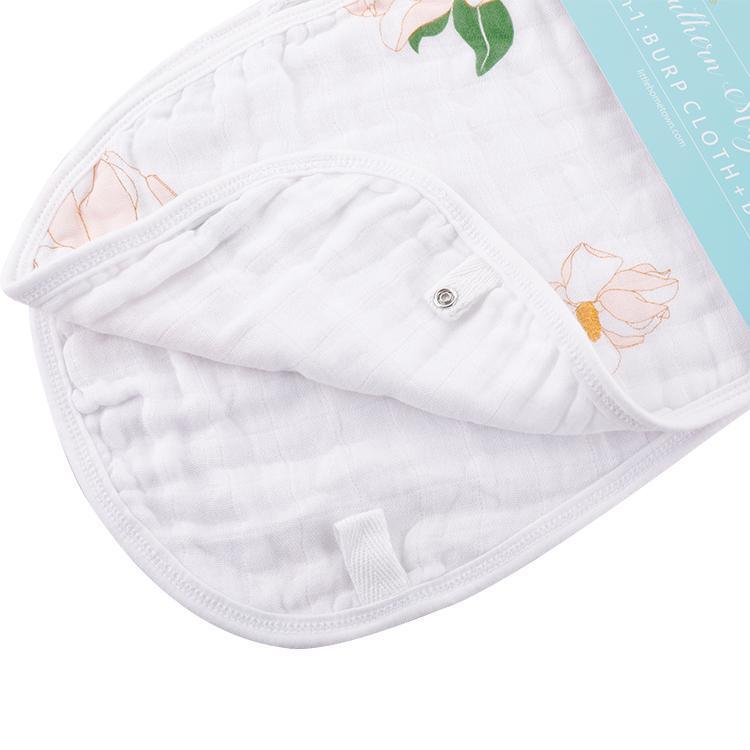 Baby bib and burp cloth set with Southern Magnolia print, featuring delicate white flowers on a soft pink background.