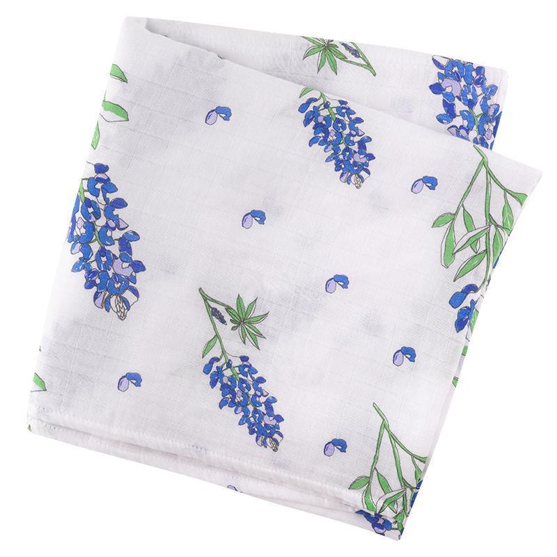 White muslin swaddle blanket adorned with delicate bluebonnet flowers, evoking a serene and gentle ambiance.