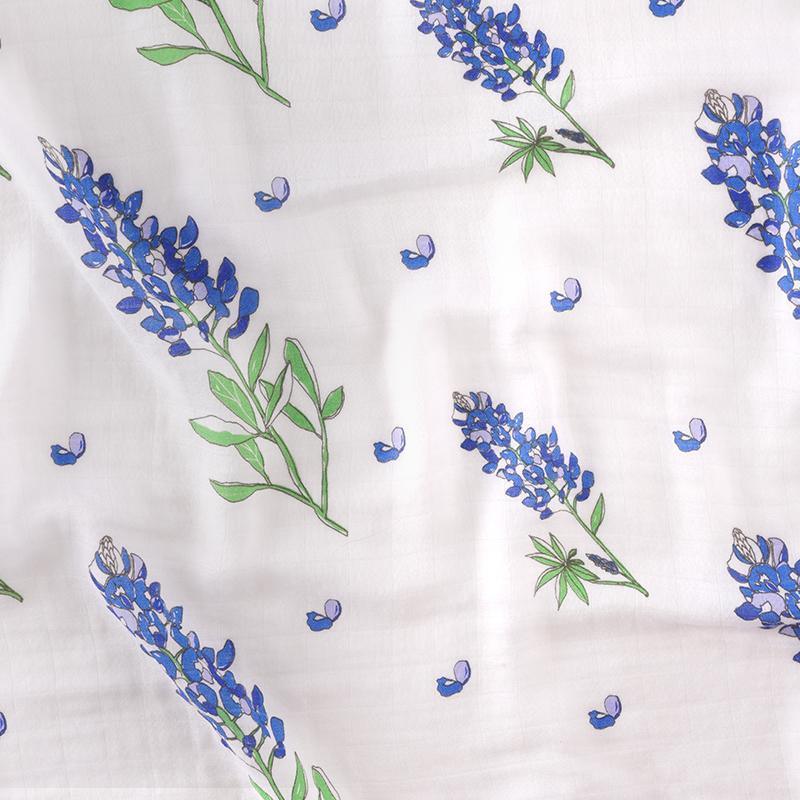 Soft baby muslin swaddle blanket with bluebonnet floral pattern, folded neatly on a white background.