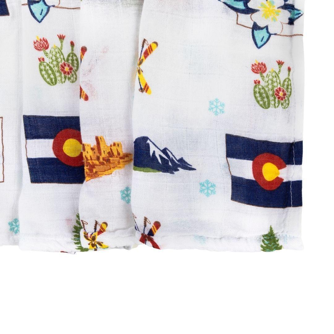 Soft muslin swaddle blanket with Colorado-themed illustrations, including mountains, bears, and pine trees.