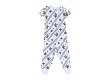 Toddler wearing white pajamas with blue fleur-de-lis pattern, standing on a white background.