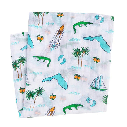 Florida-themed baby muslin swaddle blanket with colorful illustrations of palm trees, flamingos, and oranges.