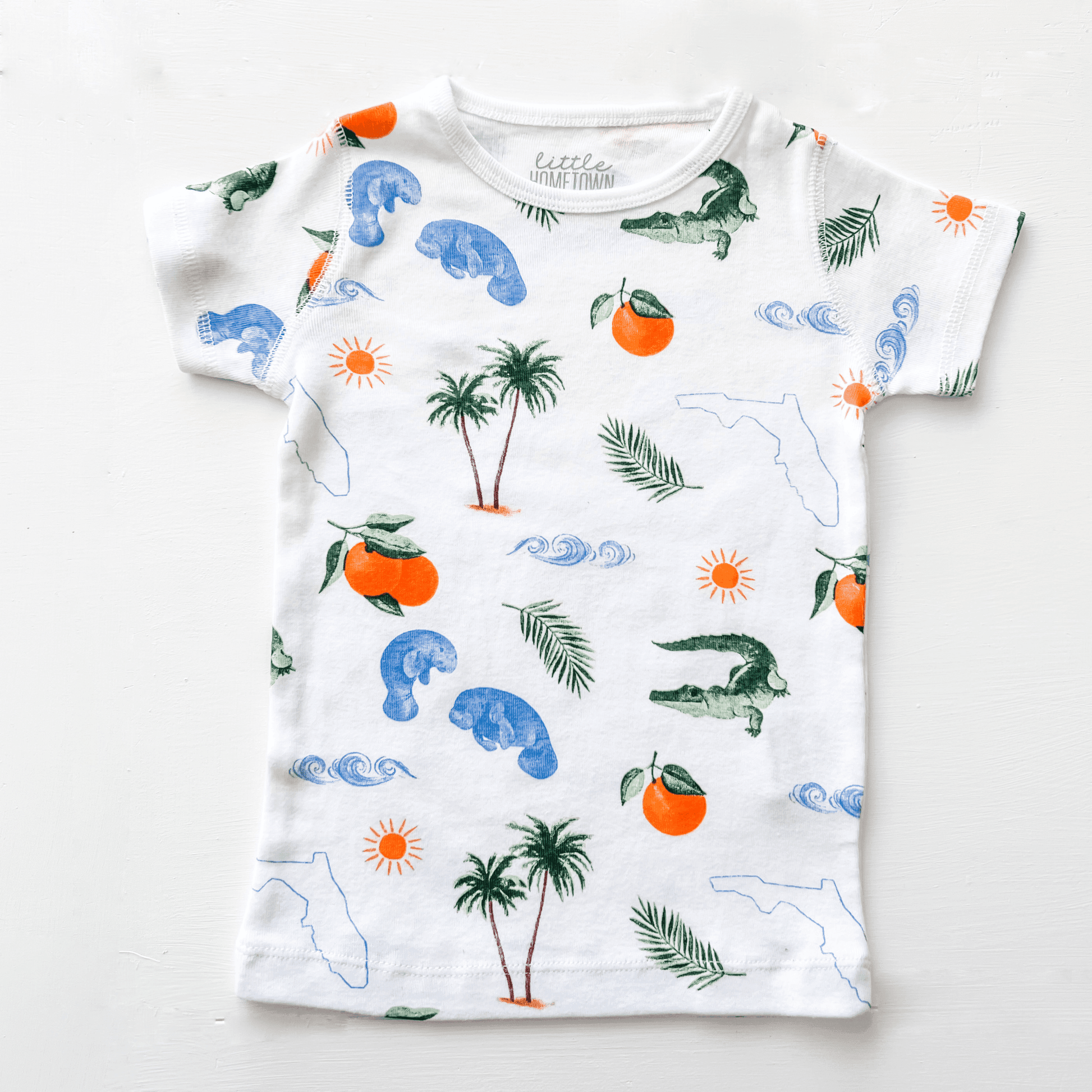 Toddler pajamas with Florida-themed illustrations, including palm trees, oranges, and alligators, on a white background.