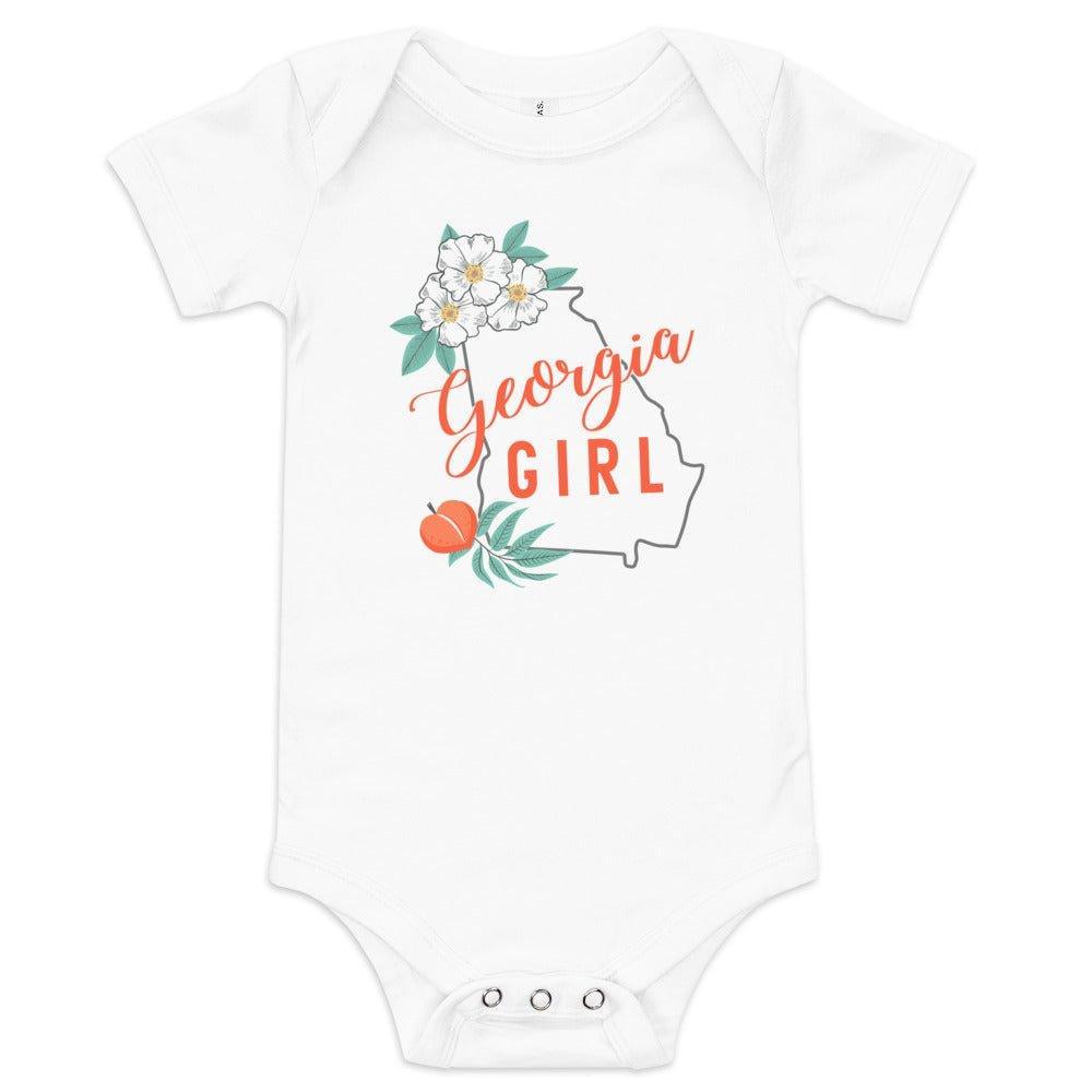 White baby onesie with "Georgia Girl" in red script and a peach graphic, displayed on a white background.