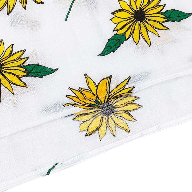 Black-eyed Susan muslin swaddle and burp cloth set, featuring vibrant yellow flowers on a white background.