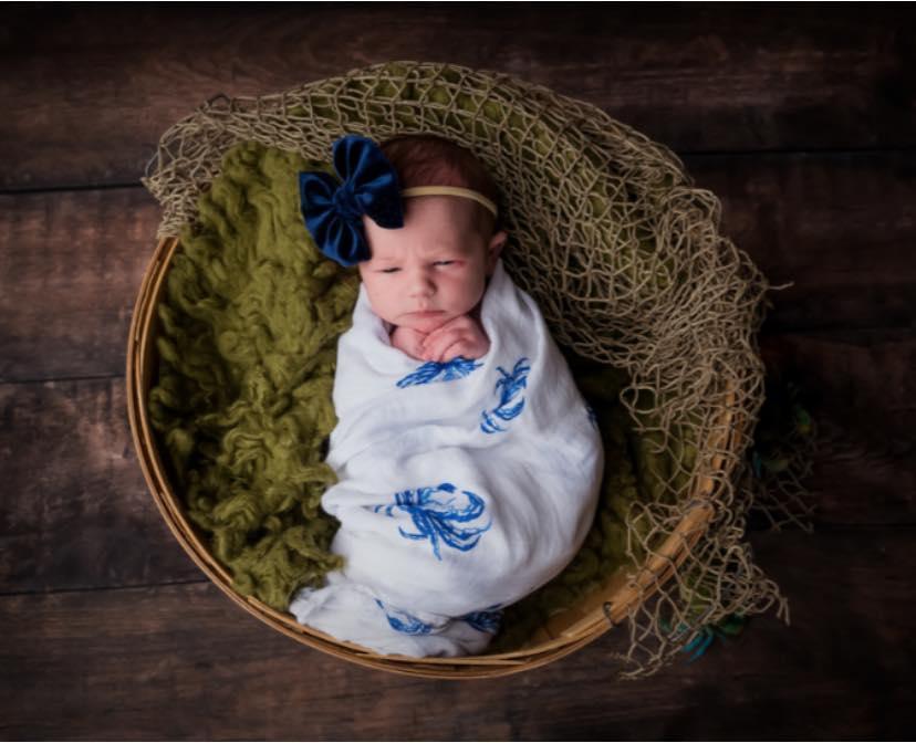 Blue crab-themed baby muslin swaddle blanket and burp cloth set, featuring playful crab illustrations on white fabric.