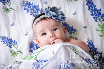 Bluebonnet-themed baby muslin swaddle blanket and burp cloth set, featuring delicate floral patterns on soft fabric.