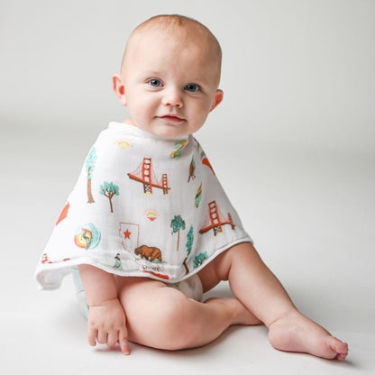 California Baby muslin swaddle blanket and burp cloth set with playful bear and tree patterns, neatly folded.