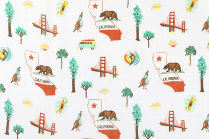 California Baby muslin swaddle blanket and burp cloth set with playful bear and tree patterns on a white background.