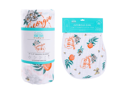 Gift set with "Georgia Girl" muslin swaddle blanket and burp cloth/bib combo, featuring peach and floral designs.