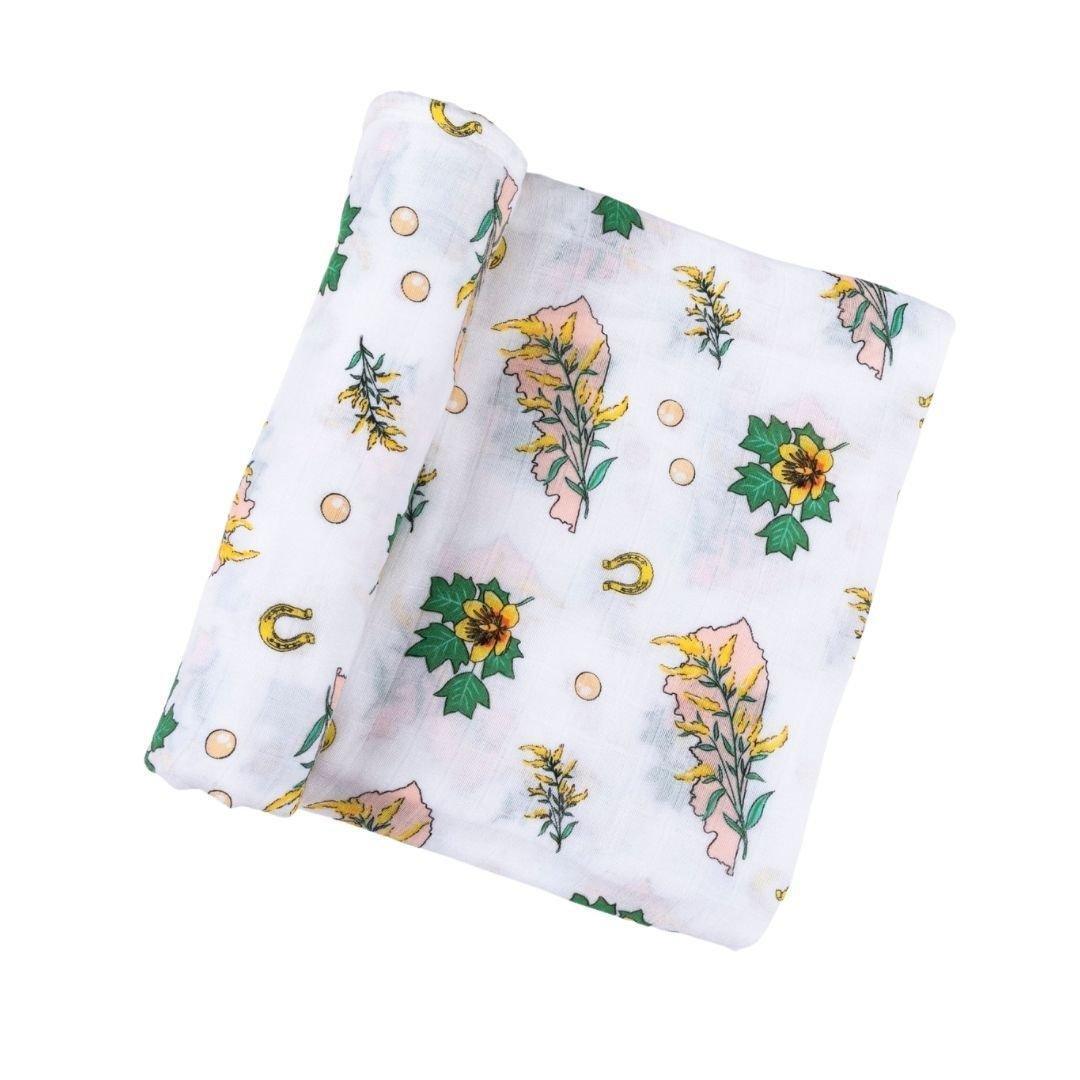 Floral-themed baby gift set with a muslin swaddle blanket and burp cloth/bib combo, featuring pink and green flowers.