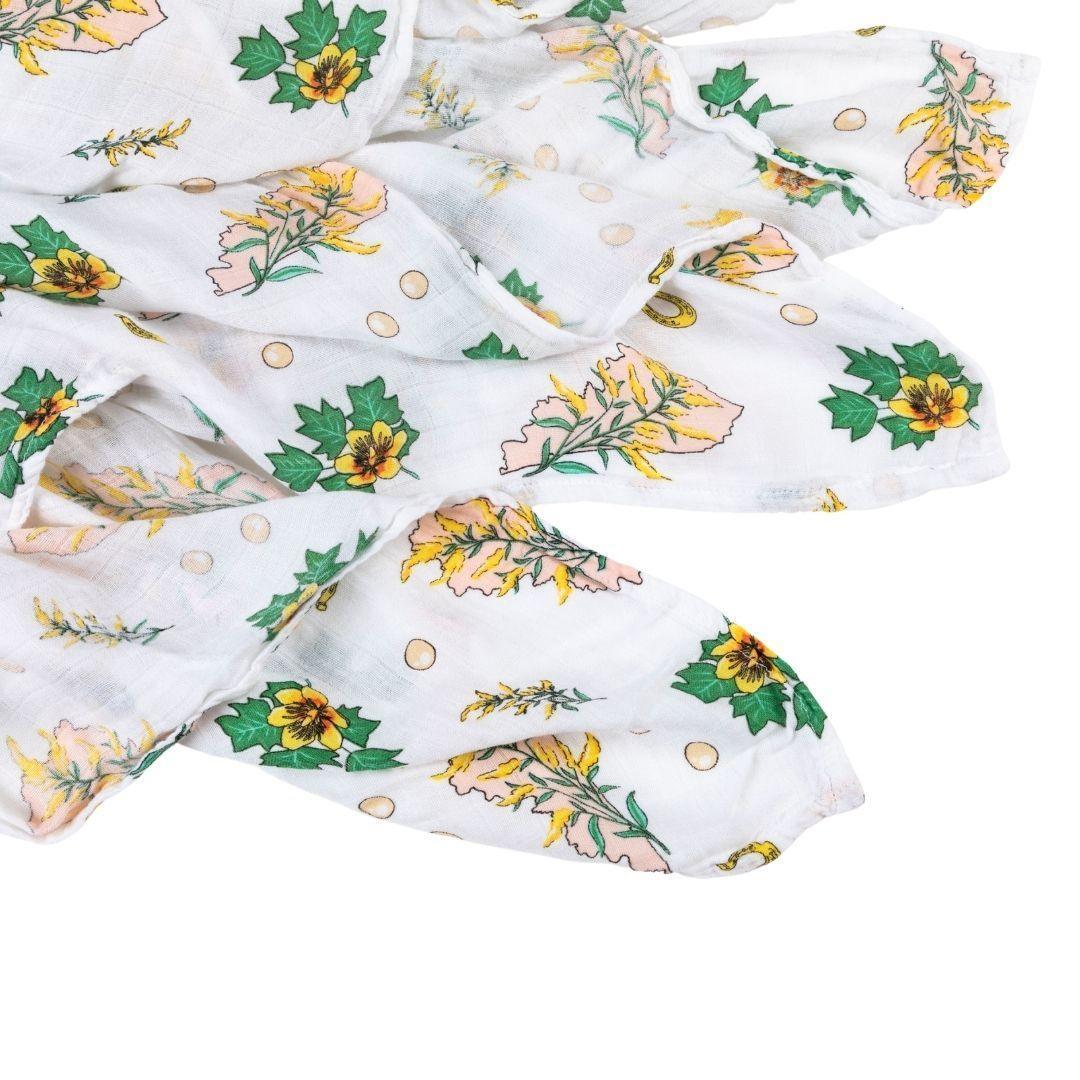 Floral-themed baby gift set with a muslin swaddle blanket and burp cloth/bib combo, featuring pink and green flowers.