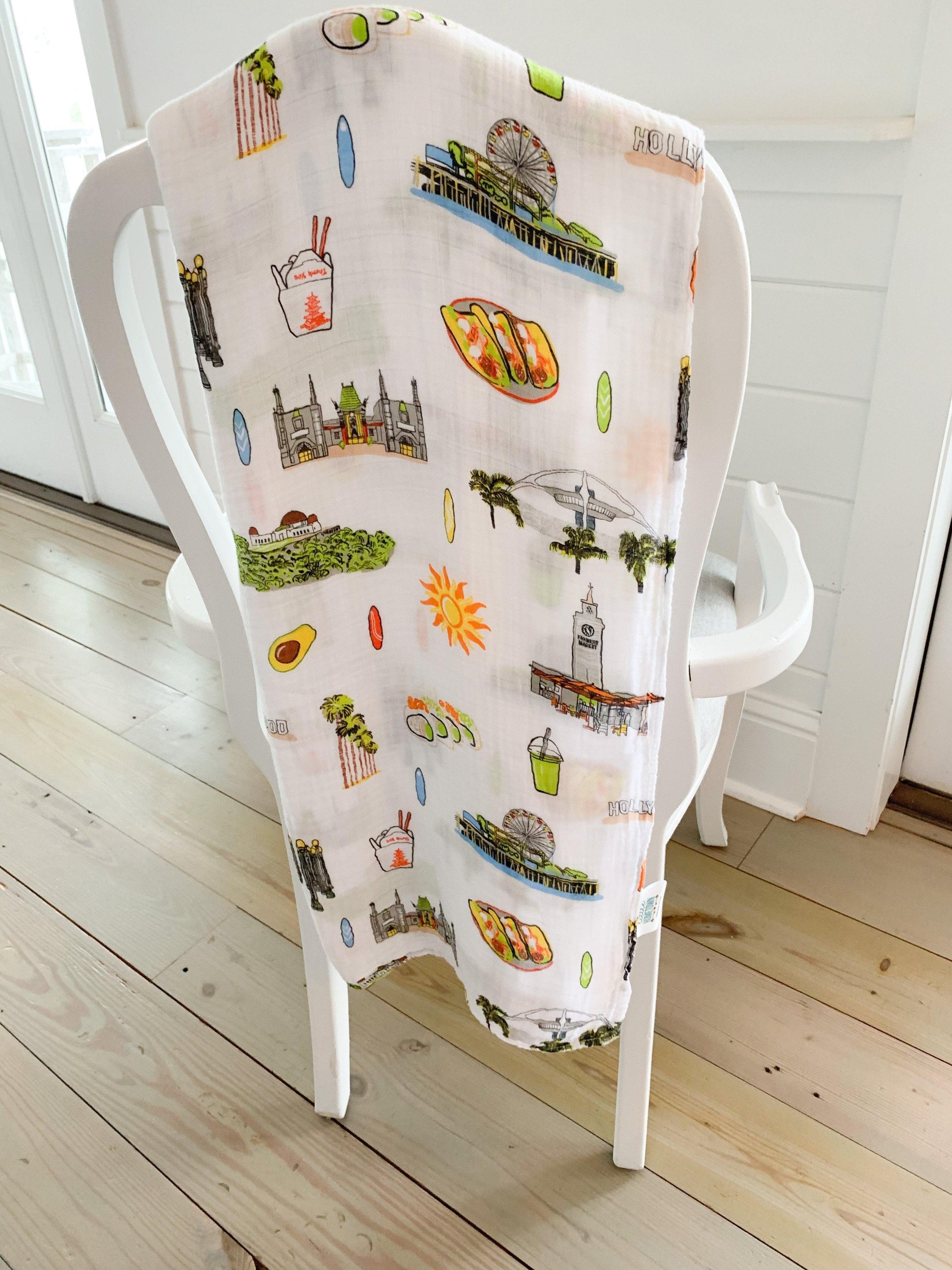 Los Angeles-themed baby gift set with muslin swaddle blanket and burp cloth, featuring iconic city landmarks.