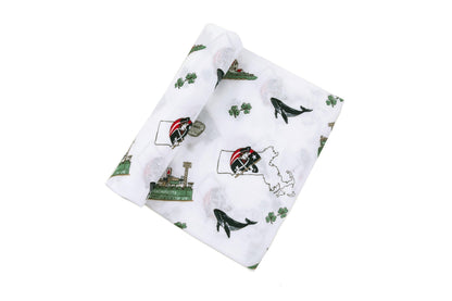 Massachusetts-themed baby gift set with muslin swaddle blanket and burp cloth, featuring state icons and landmarks.