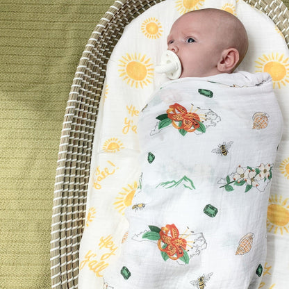 North Carolina-themed baby gift set with floral muslin swaddle blanket and matching burp cloth/bib combo.