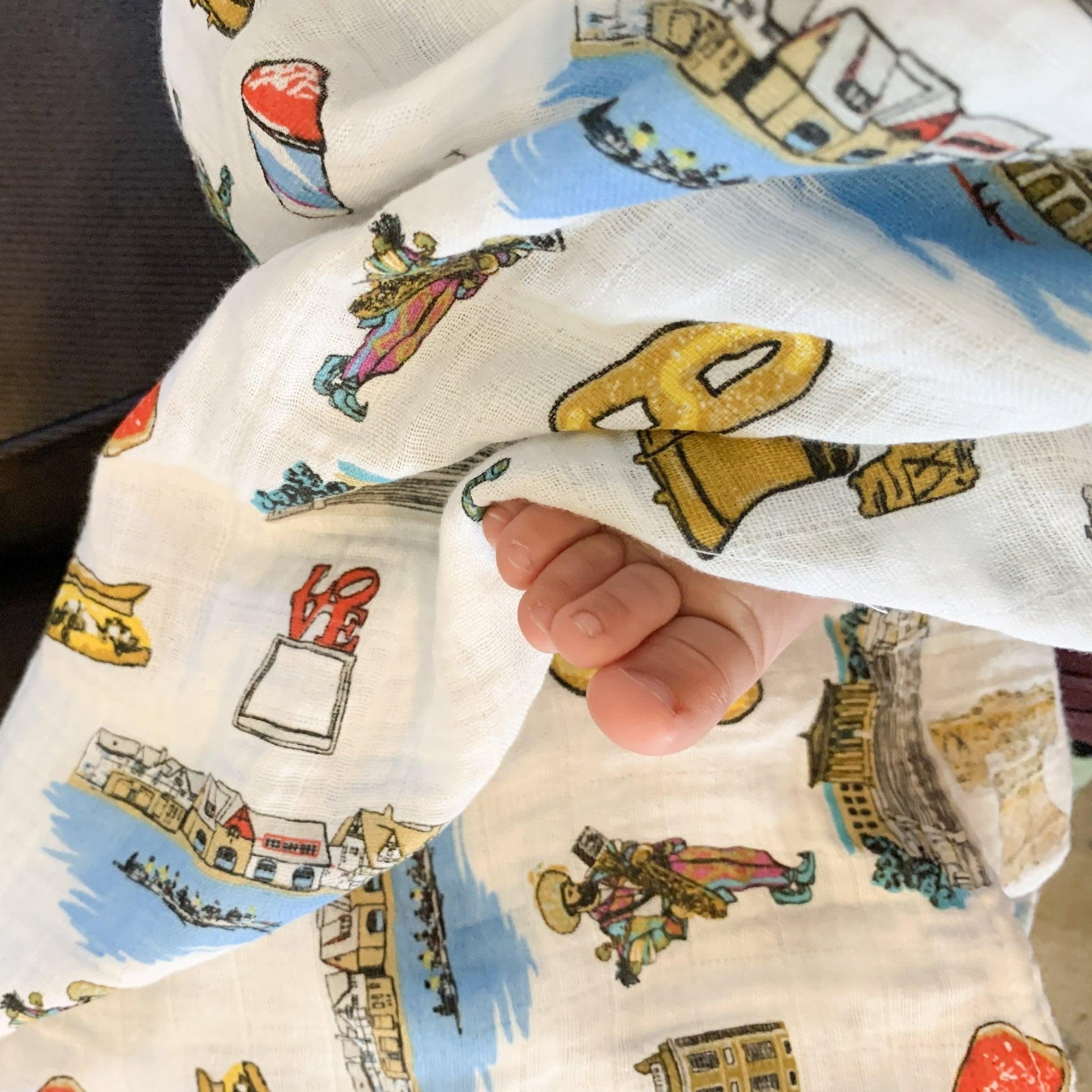 Philadelphia-themed baby gift set with muslin swaddle blanket and burp cloth, featuring iconic city landmarks.