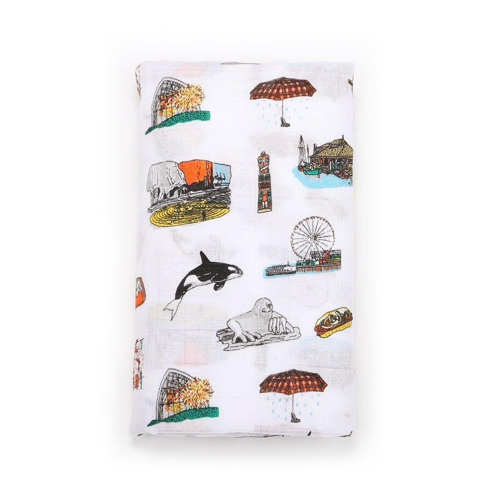 Seattle-themed baby gift set with muslin swaddle blanket, burp cloth, and bib featuring iconic city landmarks.