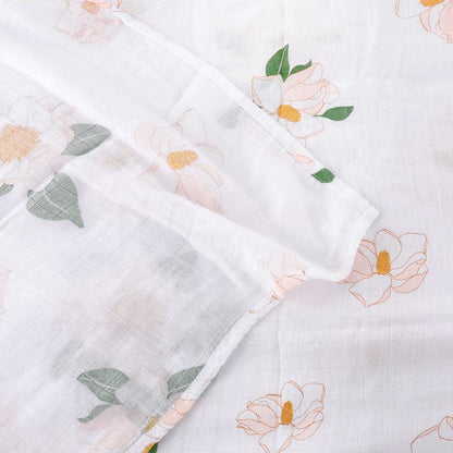 Southern Magnolia baby muslin swaddle blanket and burp cloth set with delicate floral design on a white background.