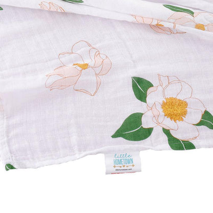 Southern Magnolia baby muslin swaddle blanket and burp cloth set, featuring delicate floral patterns in soft pastels.