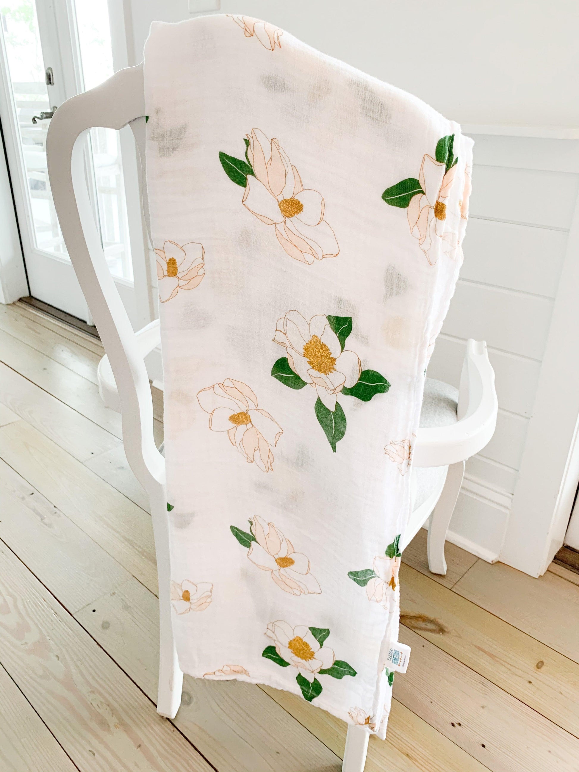 Southern Magnolia baby muslin swaddle blanket and burp cloth/bib combo, featuring delicate floral patterns.