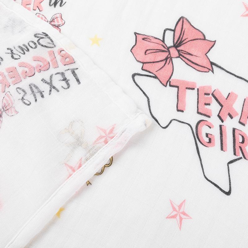 Texas-themed baby girl gift set with a muslin swaddle blanket and burp cloth/bib combo, featuring pink and white designs.