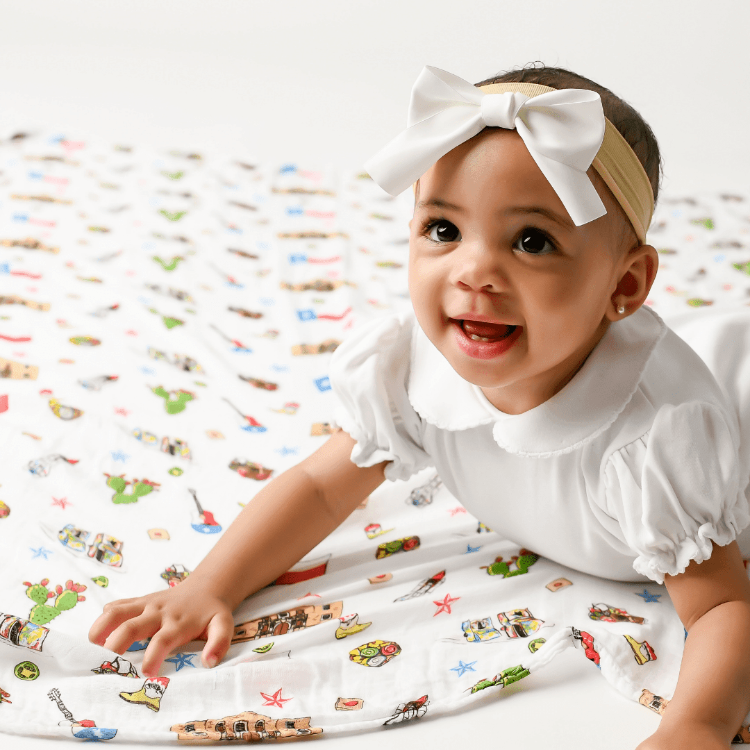 Texas-themed baby gift set with muslin swaddle blanket and burp cloth, featuring state icons and "Little Hometown" text.