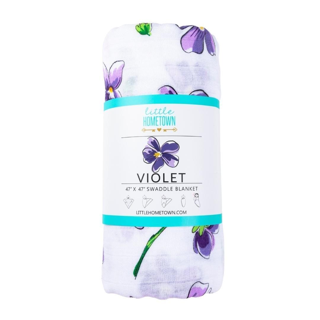 Violet baby muslin swaddle blanket and burp cloth set with delicate floral patterns, neatly folded.