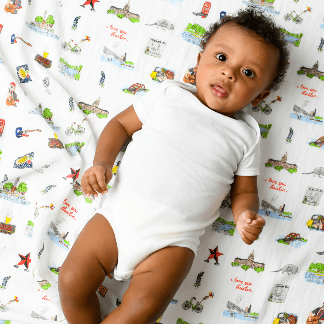 Gift set with Austin-themed baby muslin swaddle blanket and burp cloth/bib combo, featuring Texas icons.